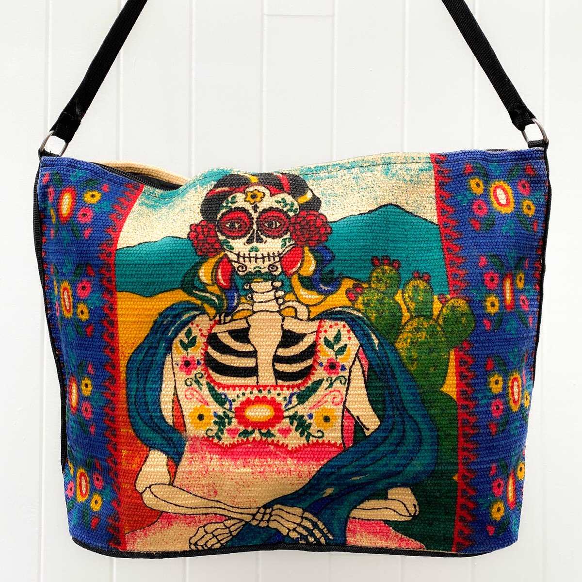 Day of the Dead Frida Kahlo skeleton with cactus design silkscreened in bright blues, red, pink, green and yellow on cotton handbag  with black cotton strap