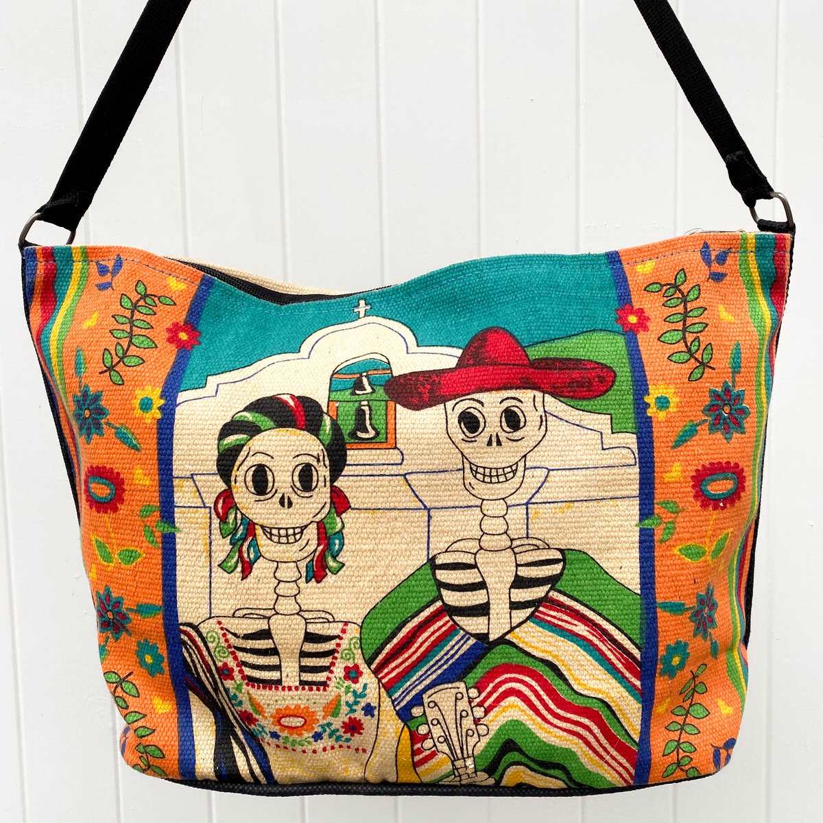 Day of the Dead American Gothic skeleton design silkscreened in bright colors, on cotton handbag with black cotton strap, shown against white background.