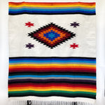 Mojave blanket Mexican-style woven in diamond and stripe design with bright rainbow colors on natural colored background