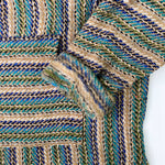 closeup of hoodie pocket and sleeve woven in greens, blues and tan